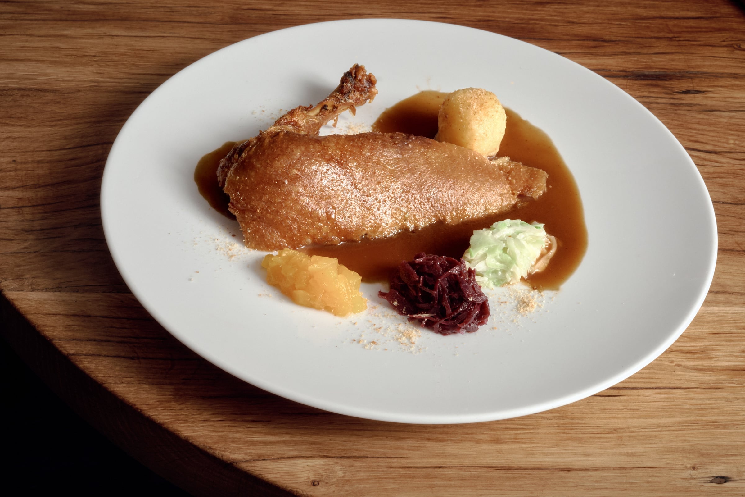 The Vierländer Ente on the plate with potato dumpling, red cabbage, savoy, apple compote and duck jus